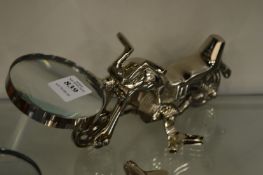 A magnifying glass the handle modelled as a motorbike.
