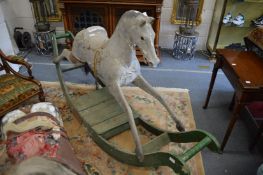 A large painted rocking horse on green painted stand (faults).