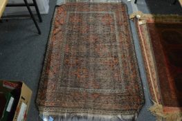 A worn Persian rug, 140cm x 92cm.