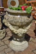 A large reconstituted stone pedestal planter.