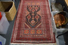 A small Persian rug, red ground with geometric decoration, 155cm x 98cm.