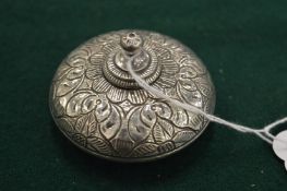 A small engraved silver perfume bottle.