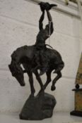 A bronze group depicting an Indian brave on horseback, possibly after an original by Remington.