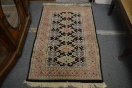 Modern Persian style rug, black ground with geometric decoration, 144cm x 94cm.