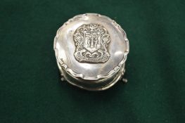 A silver dressing table box mounted with a coat of arms.
