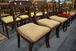A set of three 19th century mahogany dining chairs with carved backs, drop-in seats on sabre legs.