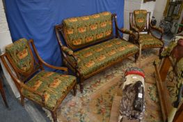 An unusual Art Nouveau carved walnut three piece salon suite comprising settee, armchair and side