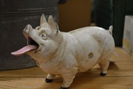 Cast iron model of a pig with articulated tongue.
