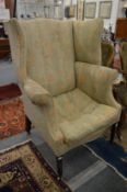 A George III mahogany framed wing armchair.