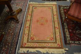 A Chinese rug, pink ground with stylised decoration, 155cm x 93cm.