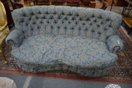 A large button upholstered two seater kidney shaped settee.