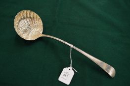 A silver ladle with shell shaped bowl.