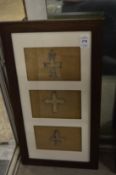 A collection of bronze crucifixes, framed and glazed.