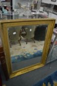 A gilt framed mirror.