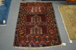 A small Persian rug, red ground with stylised decoration, 130cm x 92cm.