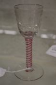 A 19th/early 20th century cordial glass with engraved bowl and coloured air twist stem.
