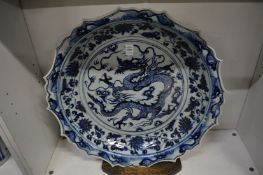 A large Chinese blue and white dish decorated with a dragon (faults).