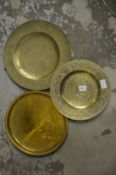 Three engraved brass dishes.