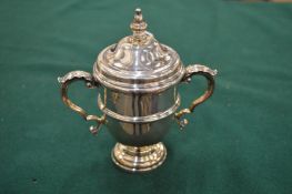 A silver twin handled trophy cup and cover.