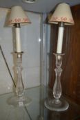 A pair of cut glass candlesticks with lamp fittings.