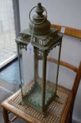 A pair of verdigris metal and glass lanterns.