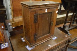 A small early oak hanging single door cupboard.