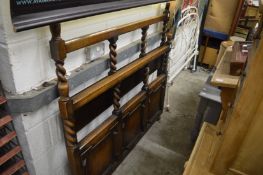 An oak bed frame and a wrought iron bed frame.