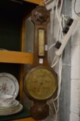 An oak cased barometer/thermometer.