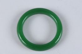 A GREEN JADE BANGLE. 3.25ins diameter.