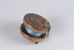 A WOODEN REEL. 4ins diameter.