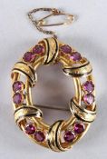 A GOOD VICTORIAN 14CT GOLD OVAL BROOCH set with twelve pink rubies. 4.5cms x 3.5cms.