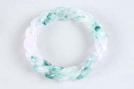 A TWO TONE JADE TWIST BANGLE. 3.5ins diameter.
