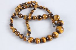A STRING OF TIGER'S EYE BEADS. 20ins long.