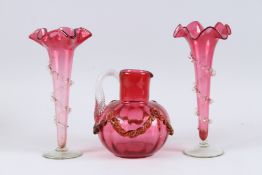 A PAIR OF VICTORIAN RUBY GLASS TAPERING FLOWER VASES, 10ins high, and a BULBOUS JUG, 6.5ins high (