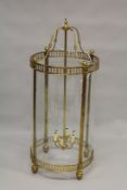 A LARGE BRASS AND GLASS HANGING LANTERN. 4ft high x 1ft 8ins diameter.