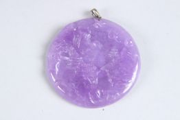 A CARVED CIRCULAR LAVENDER JADE PENDANT. 2ins high.