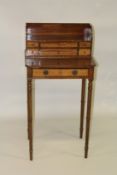 A GOOD LITTLE MAHOGANY WRITING TABLE with six drawers to the top over a long drawer and supported on