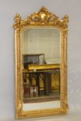 A LOUIS XVITH STYLE GILTWOOD UPRIGHT CHERUB MIRROR. 5ft 4ins high x 2ft 5ins wide.