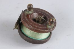 A WOODEN REEL. 3.5ins diameter.