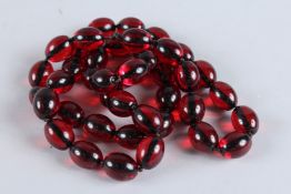 A FAUX CHERRY AMBER BEAD NECKLACE.
