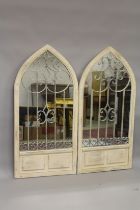 A PAIR OF WHITE ARCHED GARDEN MIRRORS. 4ft 8ins high x 2ft 2ins wide.