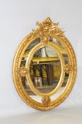 A LOUIS XVITH STYLE GILTWOOD OVAL MIRROR with shell motif. 4ft 7ins high x 2ft 10ins wide.