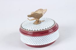 A PORCELAIN CIRCULAR BOX AND COVER with butterfly handle. 5.5ins diameter.