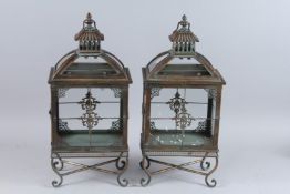 A PAIR OF RECTANGULAR COPPER LANTERNS ON FOUR CURVING LEGS. 22ins high.