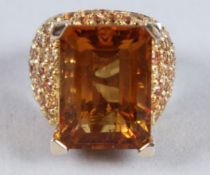 A GOOD 18CT GOLD ORANGE STONE RING with diamond shoulders.