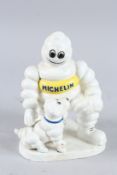 A CAST IRON MICHELIN MAN WITH A DOG. 8ins high.