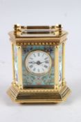 A GILT BRONZE OCTAGONAL CARRIAGE CLOCK with porcelain panels. 5.5ins high.