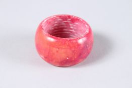 A XIU YU PLUM JADE ARCHER'S RING. 1.75ins diameter.