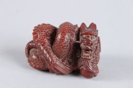 A CARVED HARDWOOD DRAGON NETSUKE. Signed. 2.25ins.