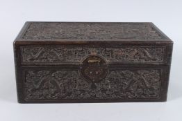 A CHINESE CARVED WOOD CASKET, with hinged cover, carved to the top, front and sides with dragons